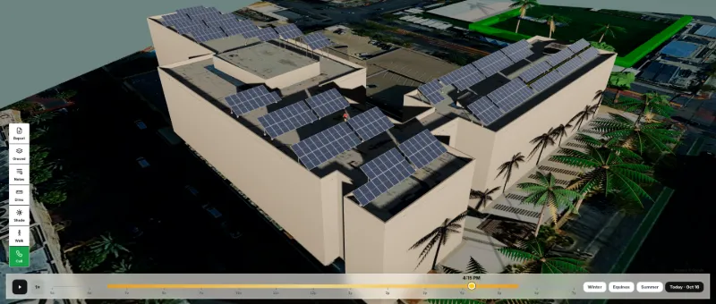 SolarDraft 3D solar design: late-afternoon aerial view of a commercial building with rooftop solar and palm trees